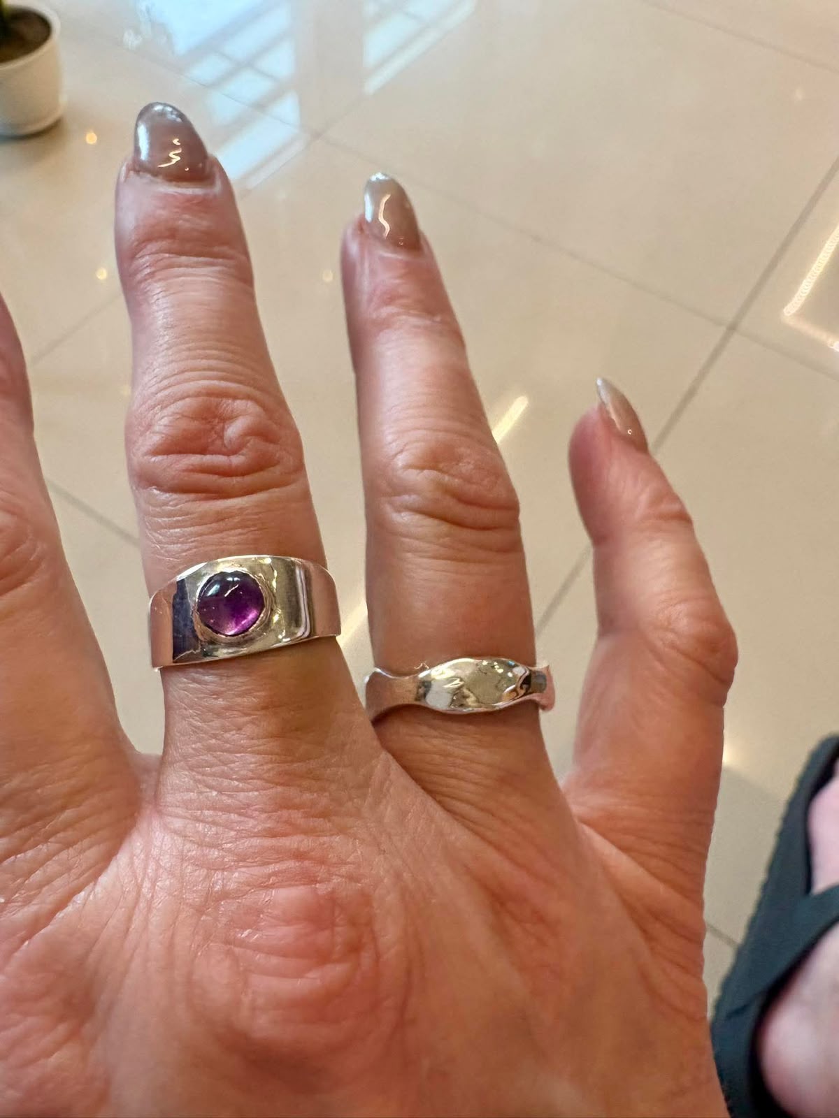 Close view of two silver rings worn on a hand