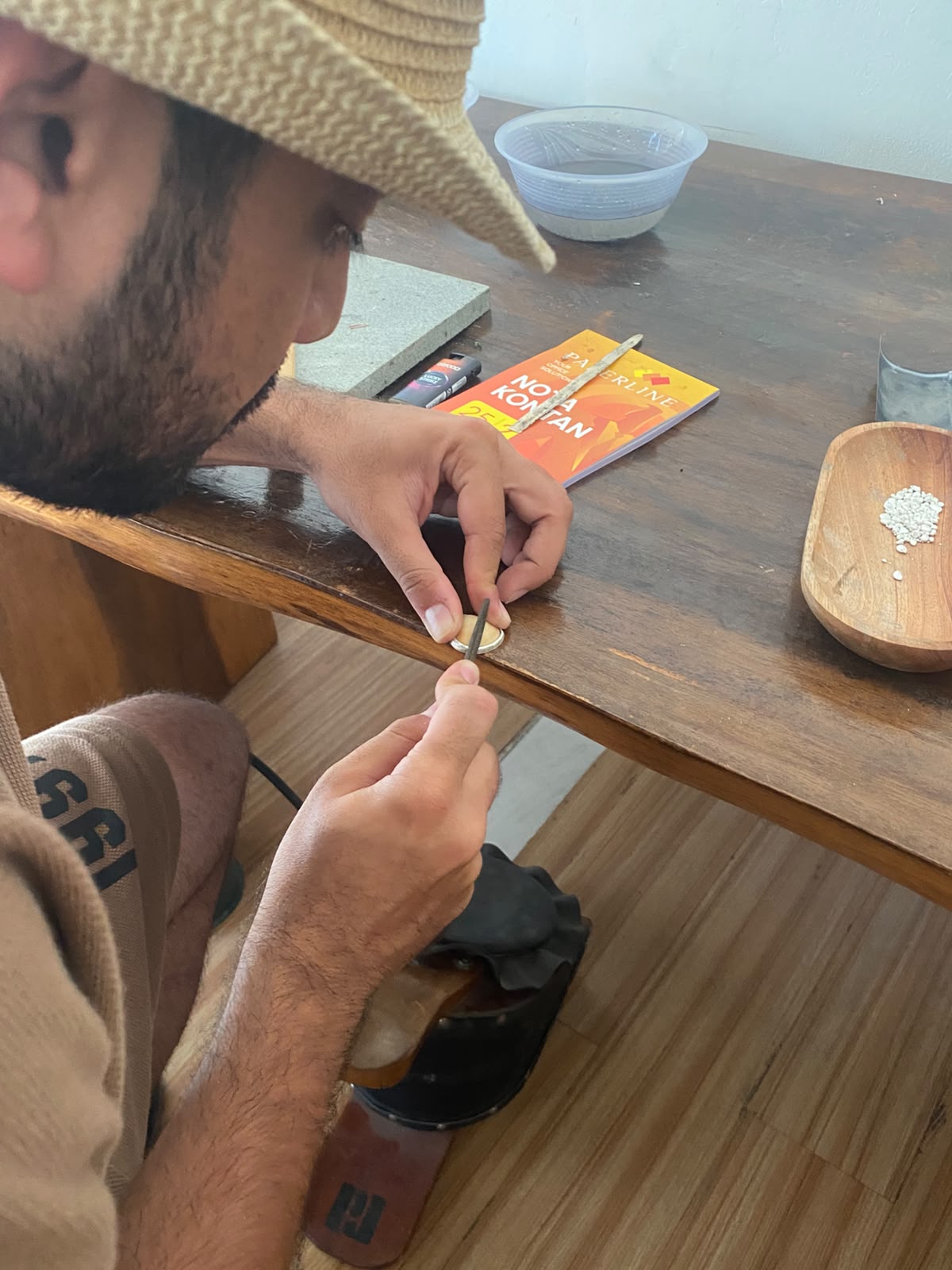A participant filing a piece of jewellery by hand