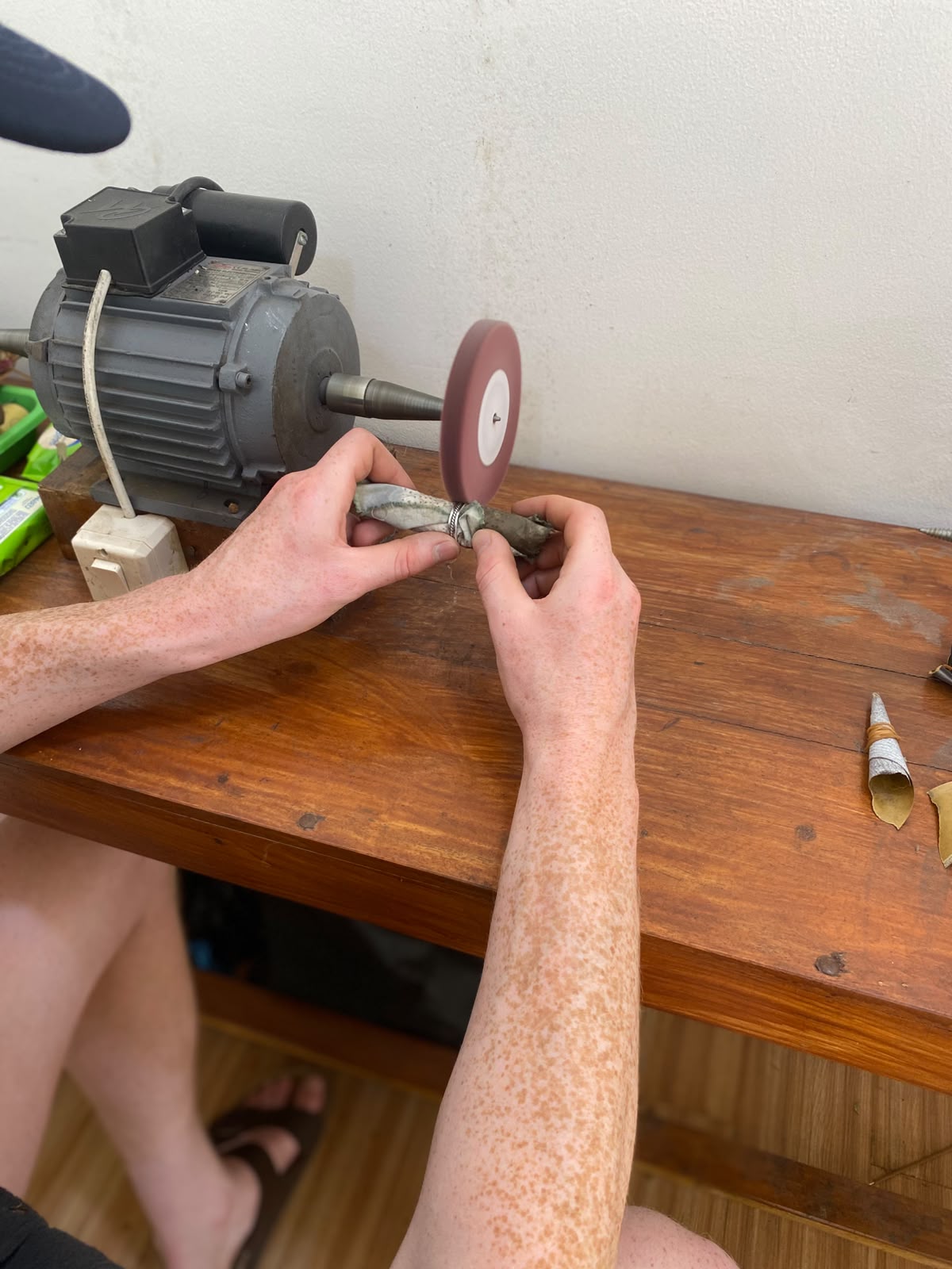 Hands polishing a silver ring at the workbench