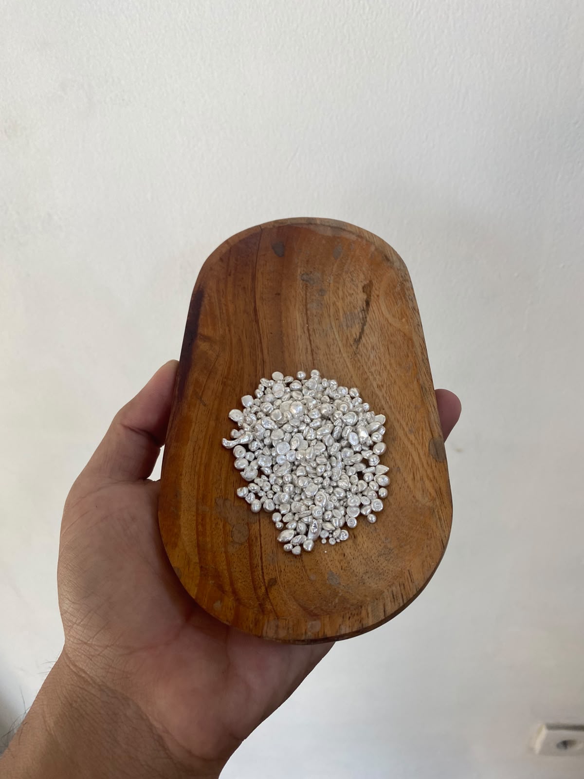 Silver granules in a wooden dish